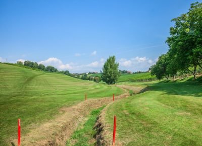 A trench on Zlati Gric golf course marked with red markers on a sunny day
